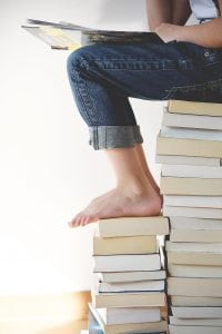 Sleep resources - woman sitting on books doing research.