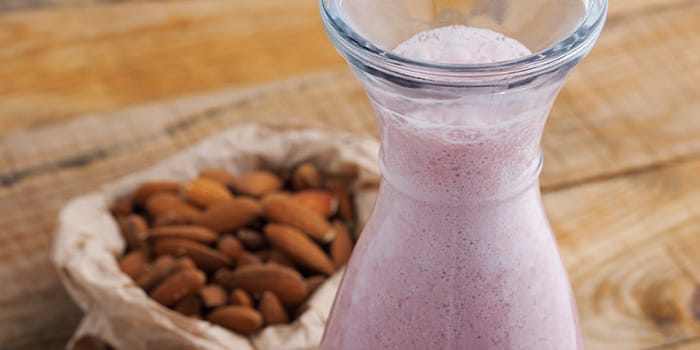 Almond Strawberry Dream Shakeology smoothie with almonds in the background
